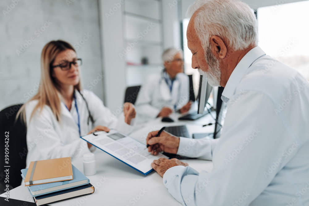 An elderly patient talking with his doctor about the medications he should use. An elderly patient talking with his doctor about the medications he should use.