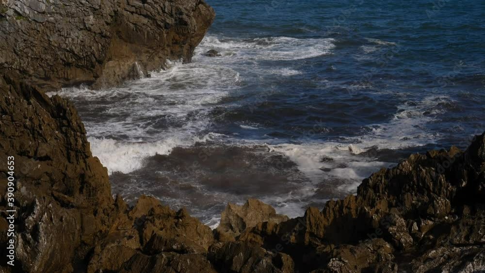 A wave breaks hard against the rocks A wave breaks hard against the rocks