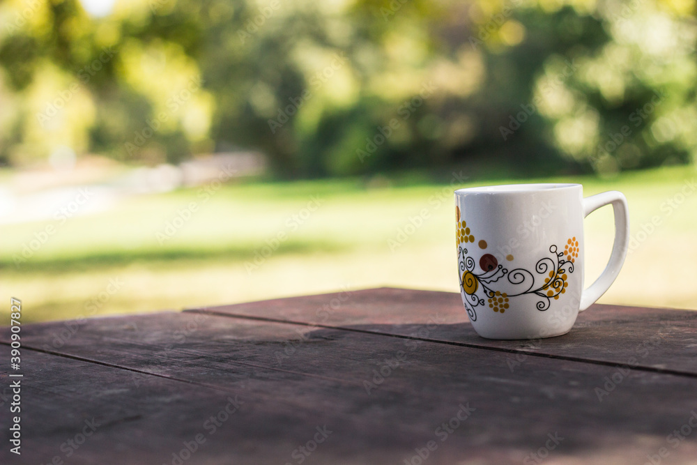 Cup coffee and sunny trees background Cup coffee and sunny trees background