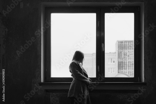 Tinted image of a young girl standing near an old window