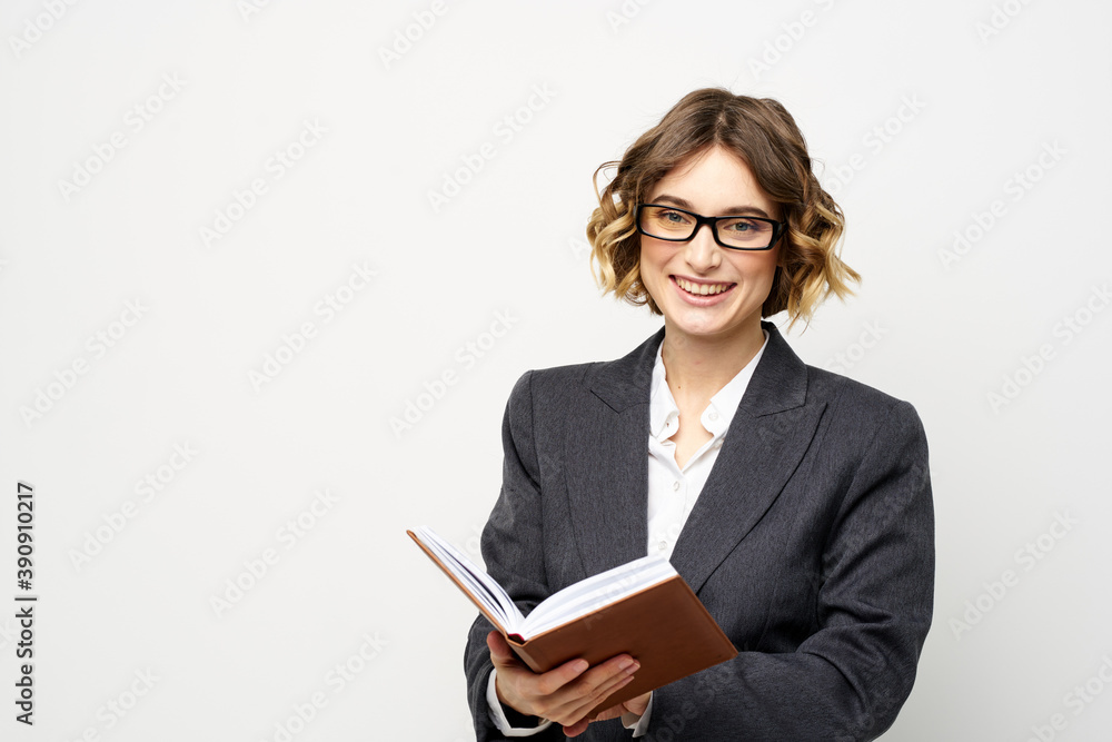 Business woman with notepad and glasses work light background cropped view of suit model. Business woman with notepad and glasses work light background cropped view of suit model.