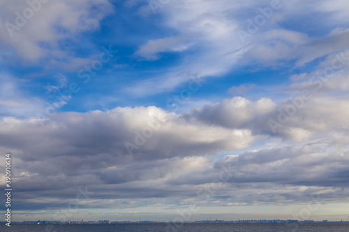 background from the blue sky with thick clouds and a line of sea below.
