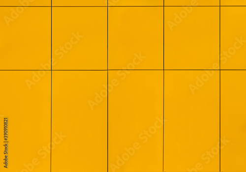 the wall of the house is covered with yellow ceramic tiles on the outside