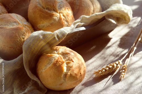 Close-up on rusty round bun, Kaiser or Vienna rolls on table covered with linen tablecloth
