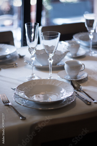 Set of porcelain tableware   prepared on a table in a modern restaurant.