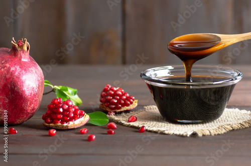 Obraz na plátně Pomegranate molasses in glass bowl, pomegranate sour sauce with fresh ripe whole