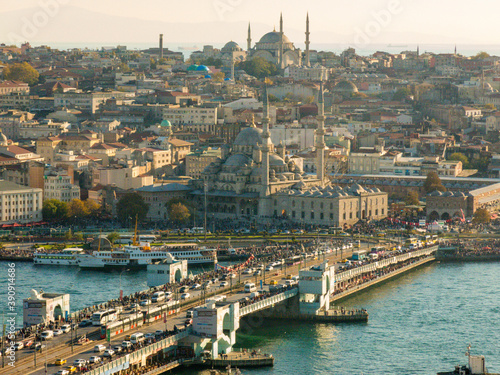 Galata bridge and Eminonu pier is very crowded during the afternoon and lots of mosques are in the background. View of Istanbul city from above at sunset.