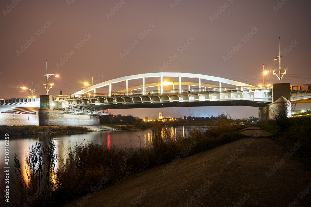 Fototapeta premium Steel structure of road bridge over the Warta river at nigh