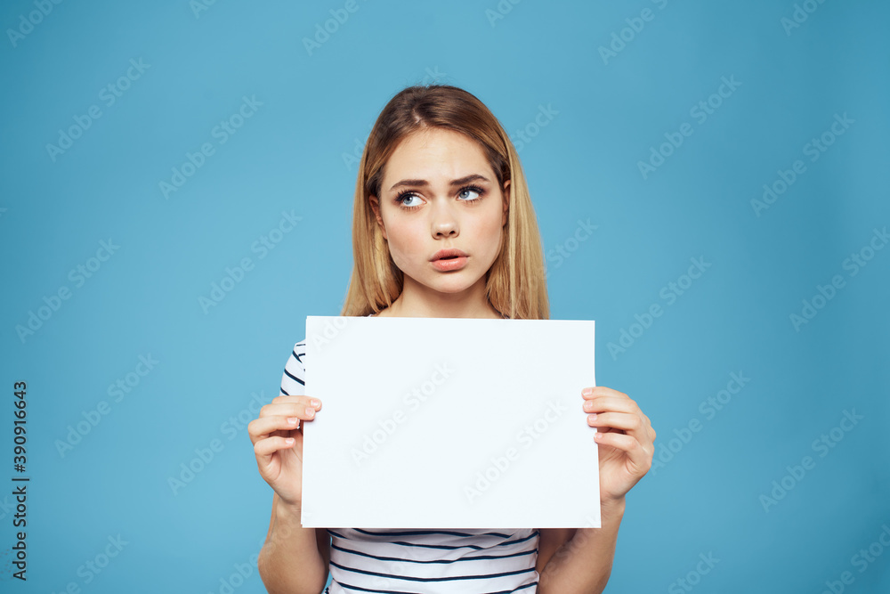 Emotional woman holding a sheet of paper in her hands lifestyle close-up blue background Copy Space Emotional woman holding a sheet of paper in her hands lifestyle close-up blue background Copy Space