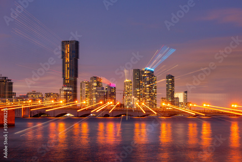 Miami skyline. Miami south beach street view with water reflections at night.