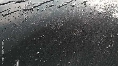 Spraying water onto a black car bonnet photo