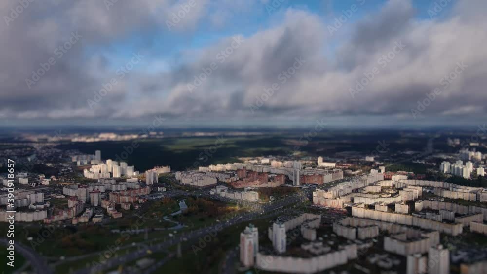 City district under the low clouds. City miniature. Tilt shift lens blur effect. Aerial downwards panoramic view of the town City district under the low clouds. City miniature. Tilt shift lens blur effect. Aerial downwards panoramic view of the town