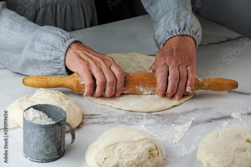 making pizza process, woman's hand working with dough and flour, white and grey background