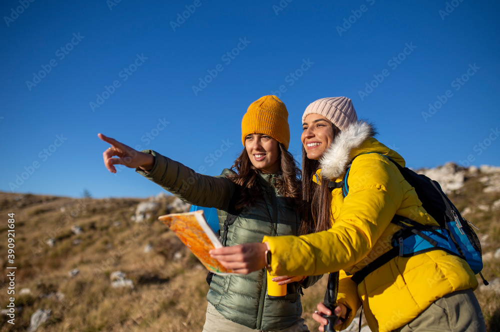 Two beautiful best friends resting and planning a new mountain route. Two beautiful best friends resting and planning a new mountain route.