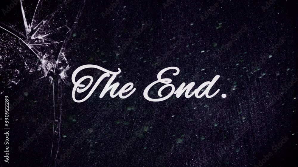 Dust floating in the air, in front of a blackboard with the written text The End, under a broken glass.
