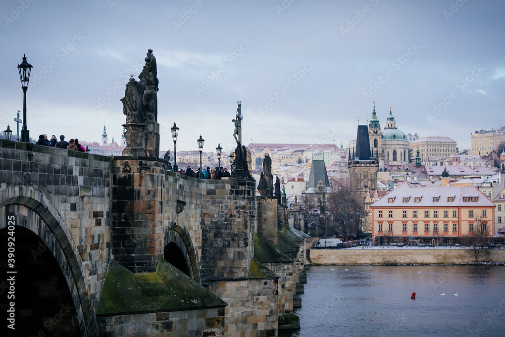 Karlov or Charles bridge and Vltava River in winter, Panoramic view of Lesser Town (Mala Strana) with bridge towers and baroque Church of St. Nicholas, Prague, Czech Republic