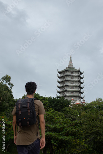 Vertical shot of a male tourist looking to the Pagoda temple, Marble mountains, Vietnam photo