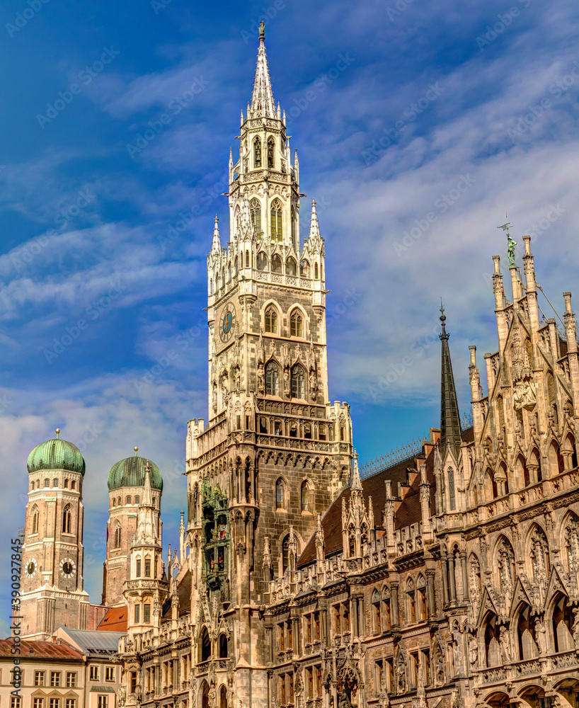 Historic Munich town hall at the Marienplatz with a Frauenkirche in the background on a sunny day.