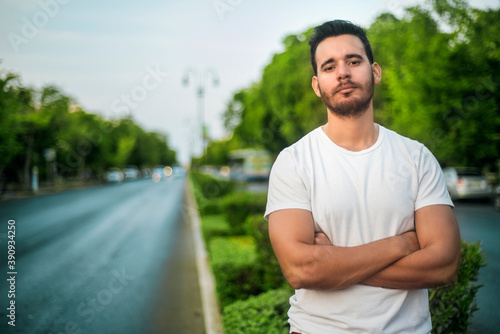 Young boy with crossed arms and imposing attitude in the street