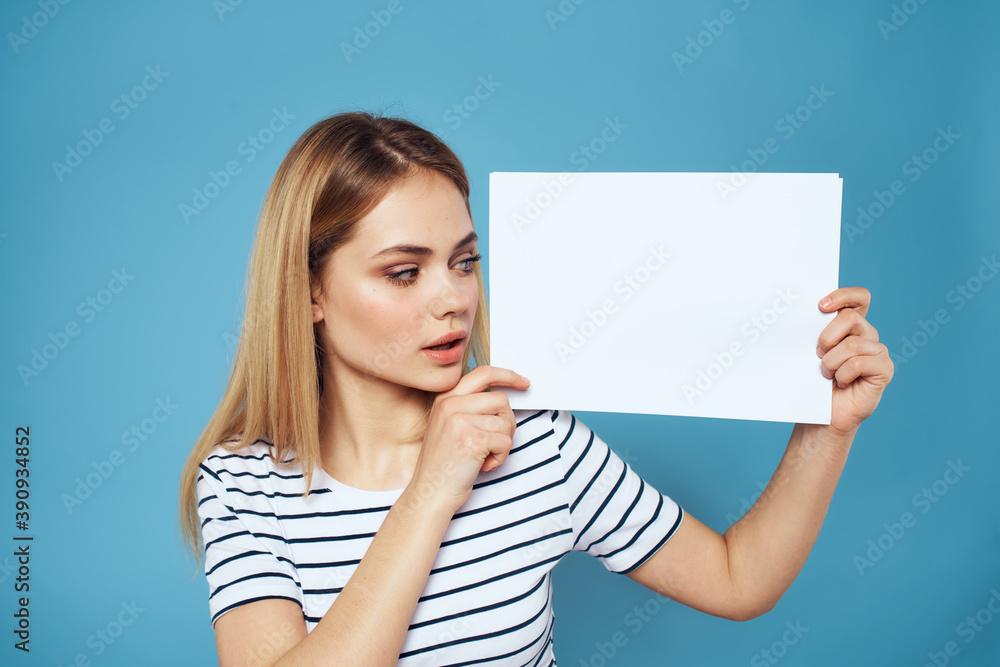 Woman holding sheet of paper striped T-shirt Copy Space cropped view blue background Woman holding sheet of paper striped T-shirt Copy Space cropped view blue background