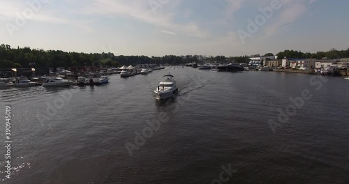 4K high quality calm windless bright summer morning aerial video of Moscow Channel yacht club embankment, green trees, wooden pier and shore with moored anchored boats and yachts near Moscow, Russia photo