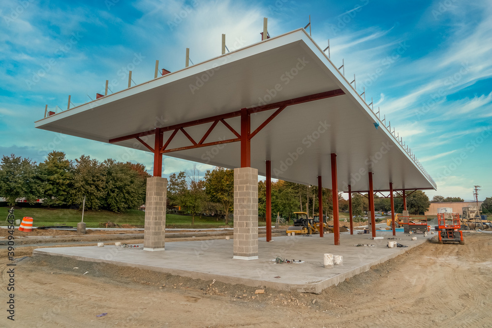 Large gas station structure under construction with steel beams dreamy blue sky background in America