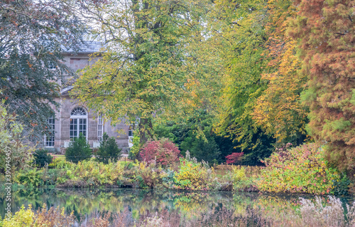 Obraz na plátně Amazing view of a stone building behind colorful autumn foliage in Weston Park,