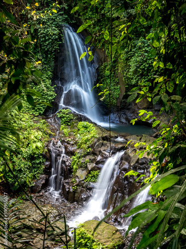 Waterfall landscape. Beautiful hidden Pengibul waterfall in rainforest. Tropical scenery. Slow shutter speed  motion photography. Nature background. Bali  Indonesia