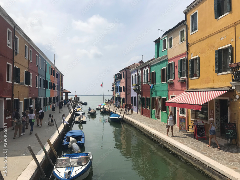 Burano island canal and colorful houses with boats in Venice Italy