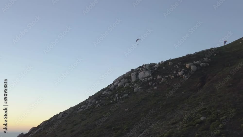 Aerial of a speedwing flying down a mountain side at sunset Aerial of a speedwing flying down a mountain side at sunset