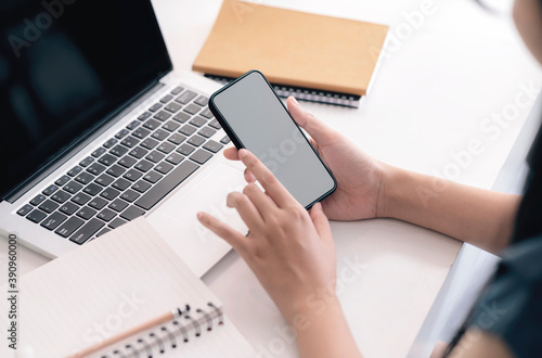 Принти на полотні Cropped shot of female hands using smartphone while sitting at her office desk