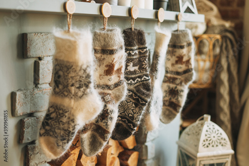 Photos Cozy fluffy wool knitted warm socks with reindeer over the fireplace in the cott