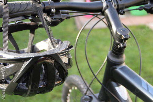 a bicycle helmet hangs on the handlebars of a mountain bike 