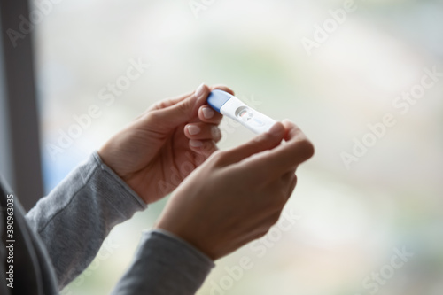 Two bars. Close up of woman hands holding positive home pregnancy test, confused female meeting unexpected gestation thinking making difficult choice, happy lady receiving news of awaited maternity