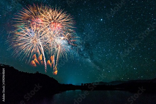 Colorful of fireworks display on milkyway in night sky background.