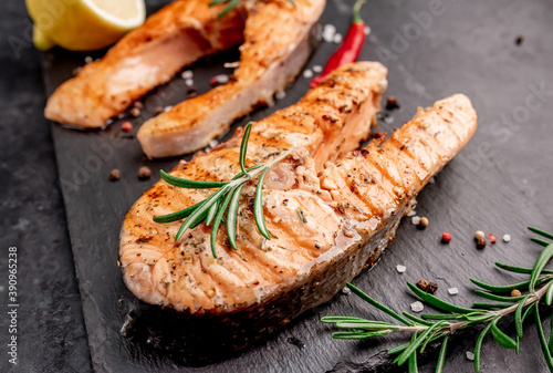 Grilled salmon steaks with spices on stone background 