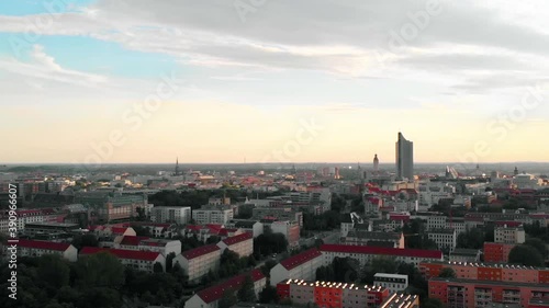 Aerial view over the cityscape of Leipzig city, towards the City-Hochhaus, during sunset, in Saxon, Germany - dolly, drone shot photo