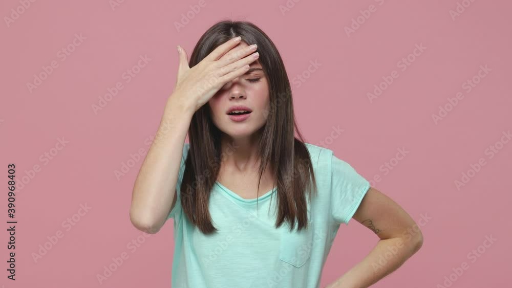 Angry irritated young brunette woman 20s years old in blue t-shirt isolated on pink background in studio. People lifestyle concept. Looking camera spreading hands screaming swearing put palm on head Angry irritated young brunette woman 20s years old in blue t-shirt isolated on pink background in studio. People lifestyle concept. Looking camera spreading hands screaming swearing put palm on head