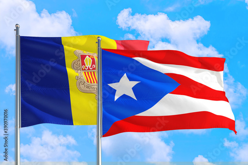 Puerto Rico and Andorra national flag waving in the windy deep blue sky. Diplomacy and international relations concept.