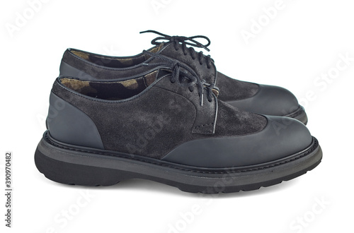 Great pair of brutal men's shoes combined from black suede and waterproof inserts on the toe and heel, on a solid sole, isolated on a white background with shadow. Side view.