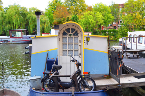 Photography Houseboat in Amsterdam. Parked scooter in a foreground.