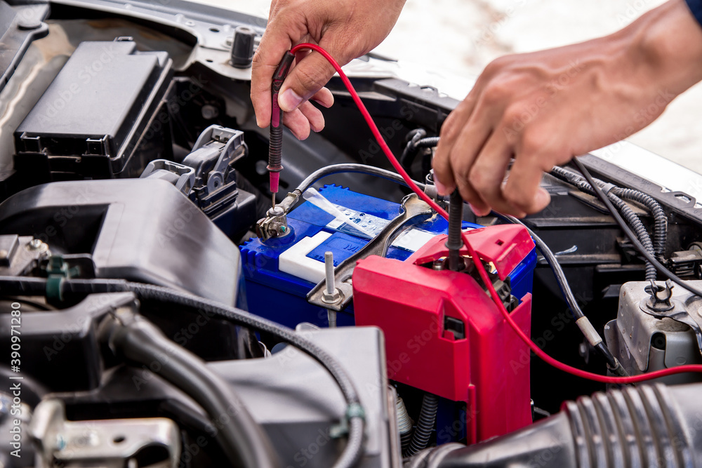 Close up hand of auto mechanic are using measuring equipment tool for checking car battery. Concepts of car fix repair and service maintenance. Close up hand of auto mechanic are using measuring equipment tool for checking car battery. Concepts of car fix repair and service maintenance.
