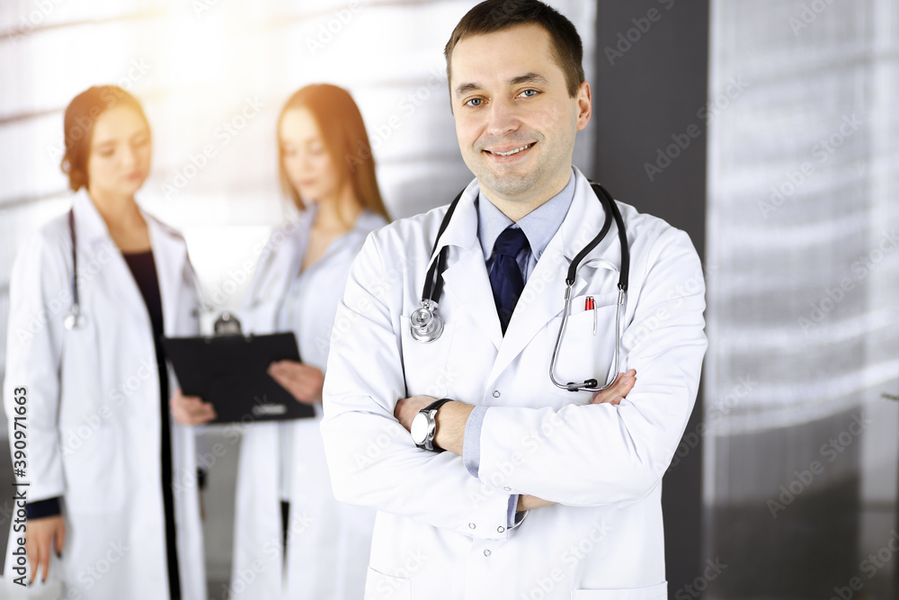 Professional middle aged doctor with a stethoscope and crossed arms at work in a sunny clinic. Perfect medical service in a hospital. Medicine concept Professional middle aged doctor with a stethoscope and crossed arms at work in a sunny clinic. Perfect medical service in a hospital. Medicine concept