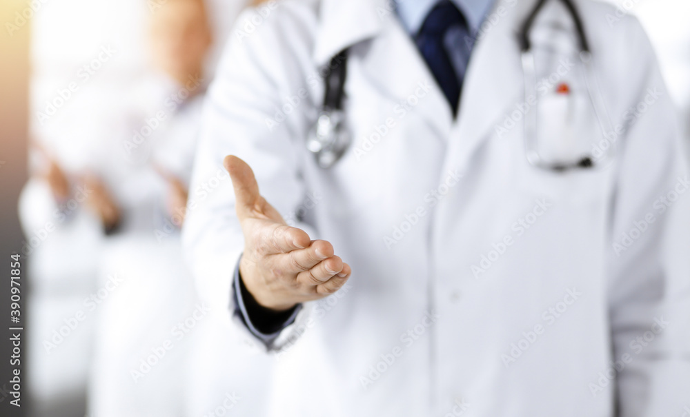 Team of friendly professional doctors are offering their helping hand for the people in a sunny clinic. Physicians are ready to help their patients. Best medicine concept Team of friendly professional doctors are offering their helping hand for the people in a sunny clinic. Physicians are ready to help their patients. Best medicine concept