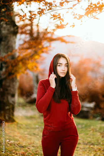 woman relax in autumn forest. Beautiful female walk in warm outfit outdoors. Mountains background.