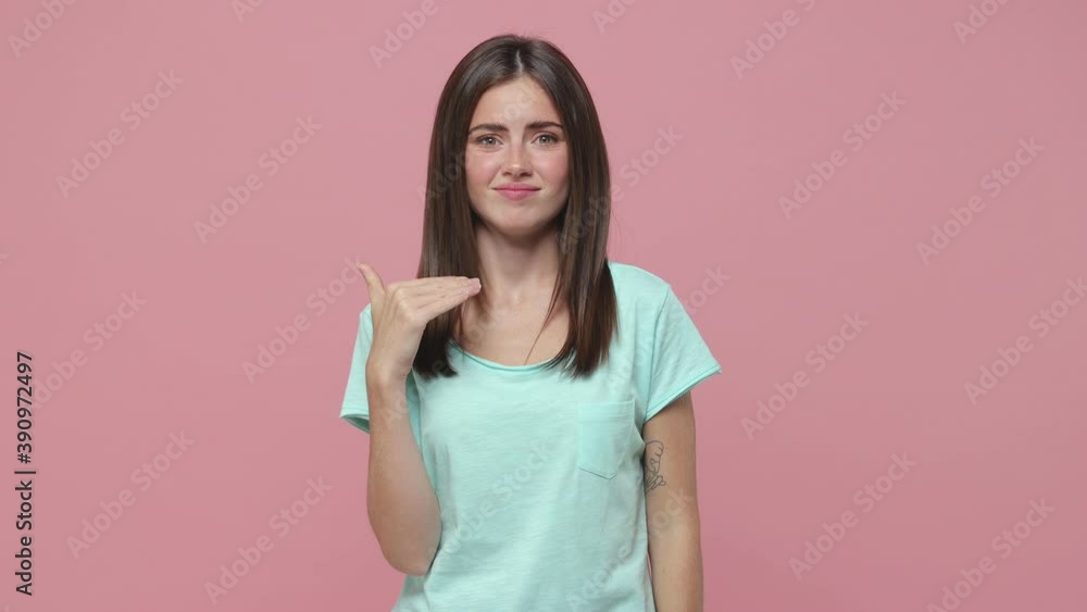 Dissatisfied young brunette woman 20s years old in blue t-shirt posing isolated on pink background studio. People lifestyle concept. Pointing fingers herself ask say who me no thanks i do not need it Dissatisfied young brunette woman 20s years old in blue t-shirt posing isolated on pink background studio. People lifestyle concept. Pointing fingers herself ask say who me no thanks i do not need it