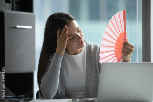 Impossible to work without air conditioner. Unhappy sad young female corporate employee feeling unhealthy overtired of extreme abnormal heat in office losing motivation enthusiasm for doing job good photo