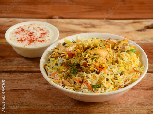 Traditional Hyderabadi Chicken dum Biryani made of Basmati rice cooked with masala spices, served with yogurt, selective focus