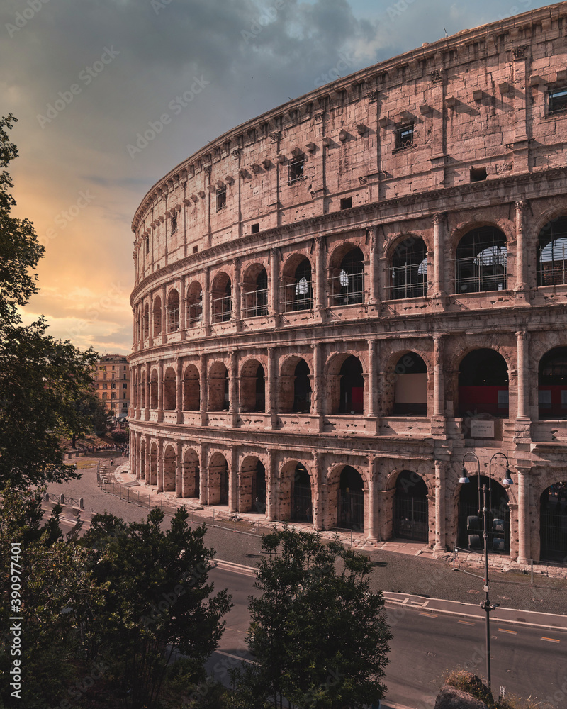 Colosseum ancient arena during sunrise with impressive sky, Rome, Italy.