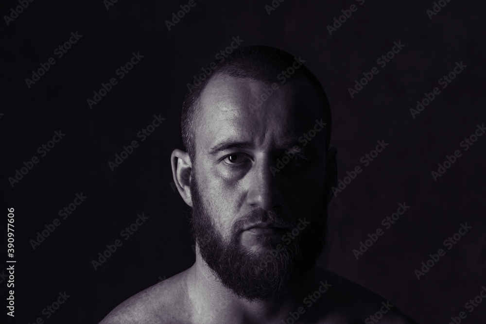 Studio session with one muscular man in low-key light conditions Studio session with one muscular man in low-key light conditions
